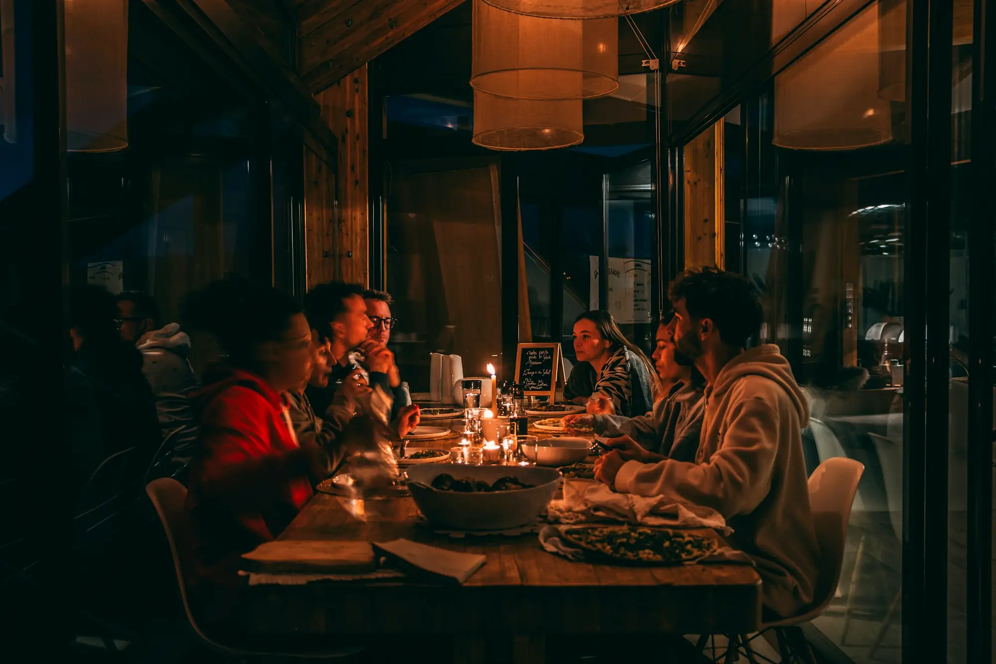 Un groupe d’amis attablés à la lueur des bougies, un soir